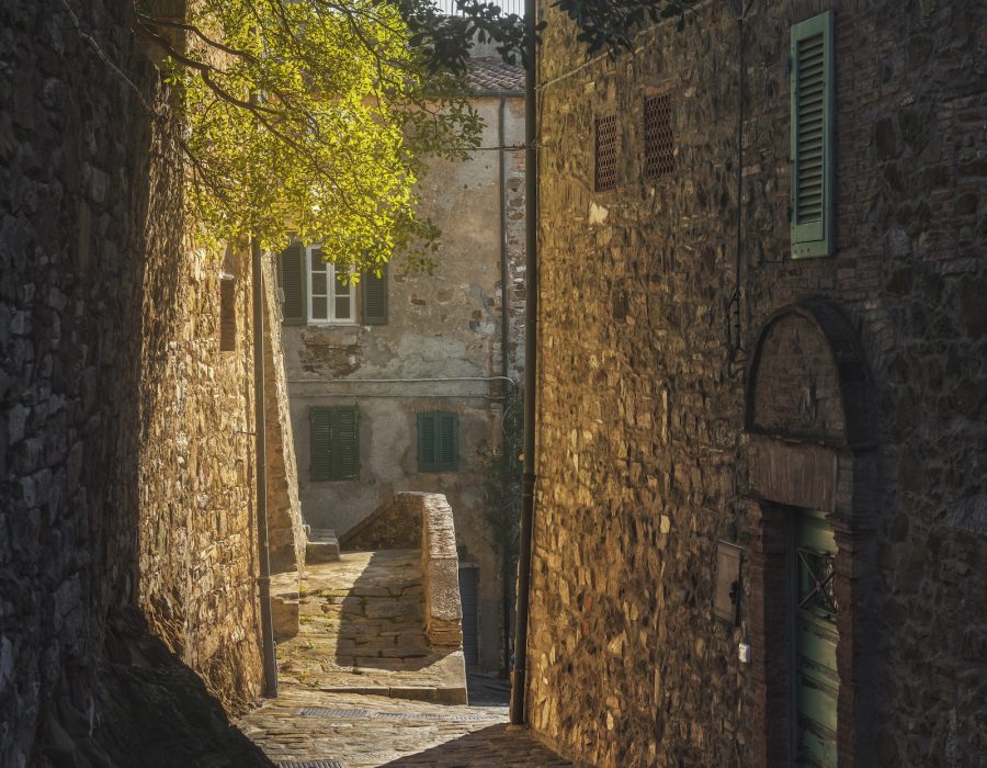 Campiglia Marittima sunlit street in old town. Tuscany, Italy